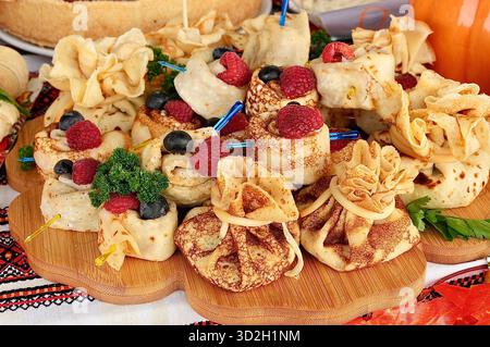 Pancake con lamponi e mirtilli su un tavolo di legno Foto Stock