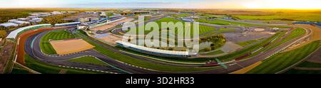 Vista aerea del circuito di Silverstone alla luce del mattino presto, con tribune, edifici a cielo aperto e tracciato della pista. Ideale per gli sport motoristici Foto Stock