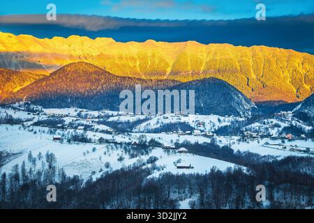Ammirevole paesaggio invernale con alte montagne innevate. Incredibile alba e le prime luci del sole sulla cresta innevata di montagna sullo sfondo, Piatra Craiului m. Foto Stock