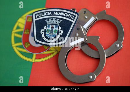 KIEV, UCRAINA - 6 SETTEMBRE 2025 Portogallo polizia municipale patch e manette sulla bandiera nazionale primo piano Foto Stock