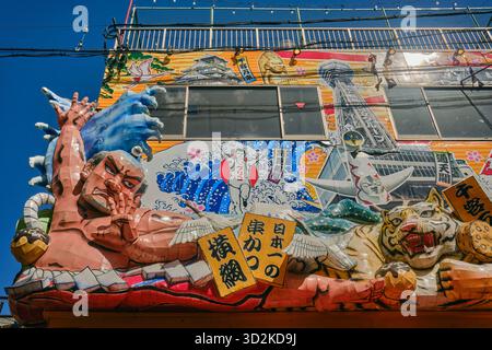Un collage di personaggi giapponesi decora un ristorante nel quartiere Shinsekai di Osaka Foto Stock