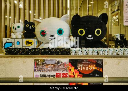 File di varie dimensioni di felpe di gatto in bianco e nero esposte nel negozio di vetro Yamato Transport lungo la via dello shopping Onomichi Hondori Foto Stock