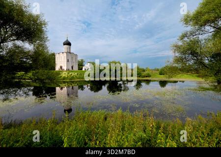 Chiesa dell'Intercessione sul Nerl riflessa sul fiume al tramonto Foto Stock