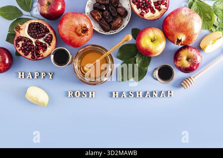 Sfondo natalizio di Capodanno per Rosh Hashanah. prelibatezze tradizionali per le vacanze. Vista dall'alto. Sfondo blu. Testo del Beato Rosh Hashanah Foto Stock