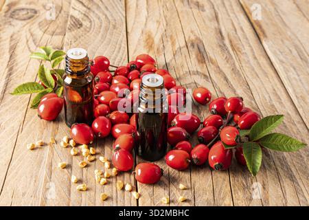 Due bottiglie mediche di vetro con un contagocce con olio essenziale di semi di rosehip per uso medico. trattamenti spa. relax. sfondo in legno Foto Stock