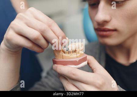 Odontoiatria. Il dentista mostra impianti al paziente. Clinica odontoiatrica Foto Stock