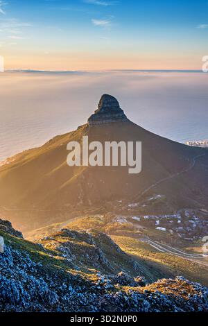 Vista della montagna di Lions Head dalla cima della Table Mountain a città del Capo, in Sud Africa, sotto la splendida luce del tramonto Foto Stock