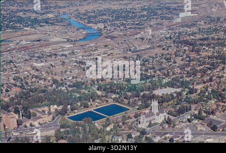 Vista aerea da cartolina della chiesa episcopale di San Giovanni e delle aree circostanti, con il lago artificiale della città sullo sfondo, Spokane, Washington, Stati Uniti, 1961. Foto Stock