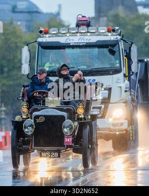 Londra, Regno Unito. 2 novembre 2025. 1904 White (Steam) di proprietà di Michael Dreelan inseguito da un camion - tempo umido mentre attraversano il Westminster Bridge - RM Sotheby's London fino al Brighton Veteran Car Run. Una conseguenza del Locomotives on the Highway Act, che ha innalzato il limite di velocità per le «locomotive leggere» da 4 mph a 14 mph e ha abolito la necessità che i veicoli siano preceduti da un uomo con bandiera rossa. La legge è stata celebrata dalla prima "Emancipation Run" quando 30 auto hanno viaggiato da Londra a Brighton il 14 novembre 1896, giorno in cui la legge è entrata in vigore. Crediti: Guy Bell/Alamy Live News Foto Stock