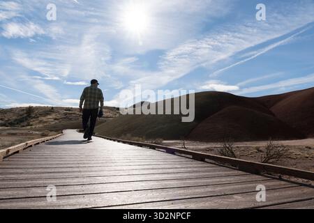 Un visitatore solitario cammina lungo le passerelle lungo il Painted Cove Trail presso il John Day Fossil Beds National Monument, Oregon, il 28 ottobre 2025. Parchi nazionali Foto Stock