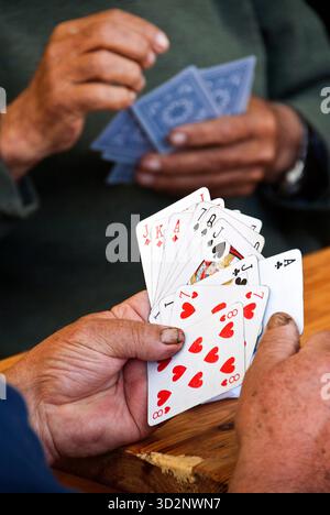 Primo piano di carte da gioco a mano su un tavolo di legno Foto Stock