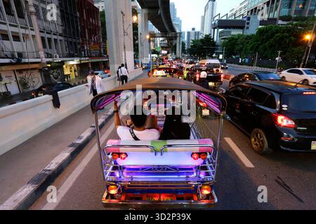 Bangkok, Thailandia - 25 luglio 2022: Coda colorata in tuk tuk tuk in un ingorgo durante l'ora di punta in un viale nel centro di Bangkok. Foto Stock
