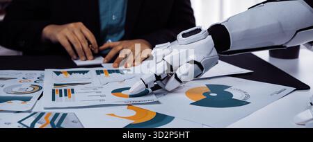 Un robot umanoide si concentra sui documenti finanziari con grafici colorati mentre un professionista aziendale gesta. Questa scena cattura l'innovazione nei corpora Foto Stock