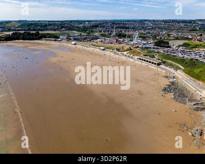 Barry, Galles - 06-30-2025: Veduta aerea con droni della famosa spiaggia di sabbia e del parco divertimenti di Barry Island, Galles Foto Stock