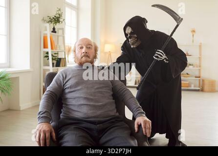 Uomo anziano molto spaventato dall'incubo Grim Reaper che lo seguì alla fine della sua vita Foto Stock