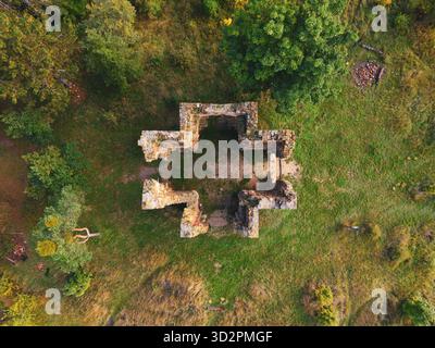 Veduta aerea delle rovine della Cappella dell'Esaltazione della Santa Croce a Bristev. Circondati dalla natura, i resti presentano pareti in pietra e una struttura a forma di croce. Foto Stock