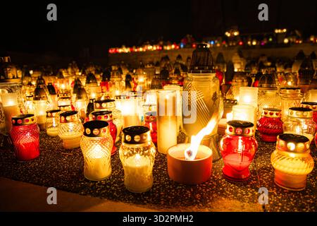 Candele e lanterne del giorno di Ognissanti al memoriale del cimitero, sfondo notturno in Polonia Foto Stock