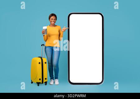 Giovane donna con valigetta e supporti per caffè accanto a smartphone Large su sfondo blu Foto Stock