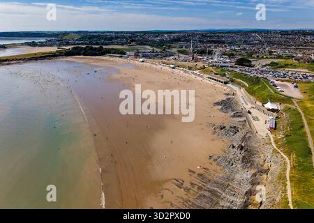 Persone che si godono una giornata estiva soleggiata sulla spiaggia sabbiosa del resort di Barry Island Foto Stock