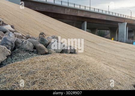 Controllo dell'erosione in pendenza con coperta a rete singola installata a terra per proteggere da erbacce e acqua Foto Stock