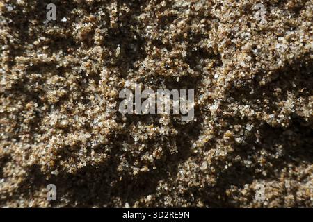 Sfondo macro di sabbia granulare marrone che mostra una consistenza grossolana e naturale. il motivo a cristalli astratti evoca una sensazione di semplicità, dettagli terrosi e puro compagno Foto Stock