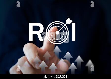 Concetto di ROI con un uomo d'affari che tocca il target virtuale e il simbolo della freccia che rappresenta il ritorno sull'investimento, la crescita del profitto, la strategia di marketing, la p Foto Stock
