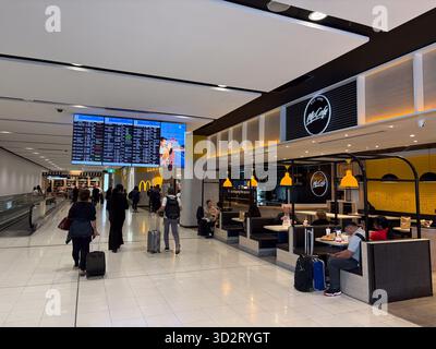 McDonald's McCafé, ristorante fast food all'interno del trafficato terminal dell'aeroporto di Sydney, Australia, con viaggiatori a piedi e altri ristoranti. Un grande fli Foto Stock
