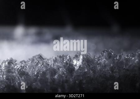Macro-view dettagliata che rivela l'intricata trama di numerosi cristalli di ghiaccio. Questa superficie ghiacciata trasporta freddo e freddo, mostrando delicati Foto Stock