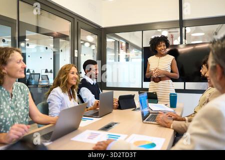 Diversi team aziendali collaborano durante la presentazione della riunione d'ufficio Foto Stock
