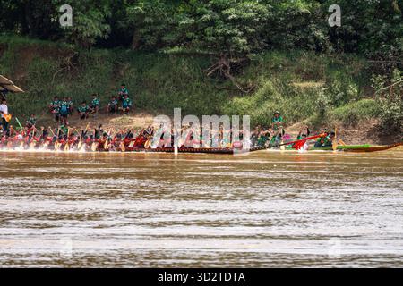 Emozionante corsa in barca sul fiume fangoso, Attapeu, Laos - festival Boun Suang Heua, competizioni tradizionali, cultura Mekong ed energia Foto Stock