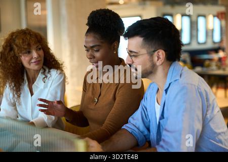 Team aziendali diversificati che collaborano durante le discussioni in ufficio Foto Stock