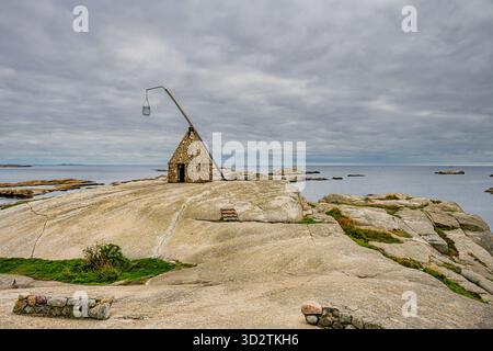 Le scogliere costiere di fine mondo a Tjøme, in Norvegia, con il faro inclinabile costruito con ciottoli nel 1932, che si affaccia sul fiordo di Oslofjord. Foto Stock