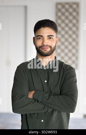 Ritratto di un giovane uomo arabo, impiegato in ufficio al chiuso Foto Stock