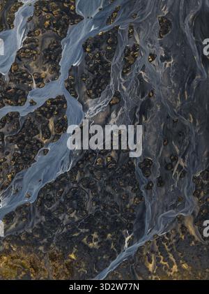 Vista aerea dei fiumi glaciali che si intrecciano attraverso sabbie vulcaniche scure, creando intricati motivi sulla costa meridionale, Islanda. Foto Stock
