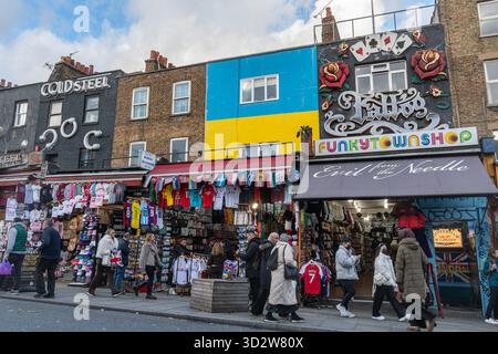 Negozi su Camden High Street a Camden Town, Londra, Inghilterra, Regno Unito. Colorate facciate di negozi con gente che fa shopping Foto Stock