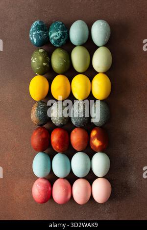Le uova di Pasqua dai colori vivaci sono disposte in una griglia, con tonalità di rosa, blu, verde e giallo. Queste uova simboleggiano il rinnovamento e lo sono spesso Foto Stock