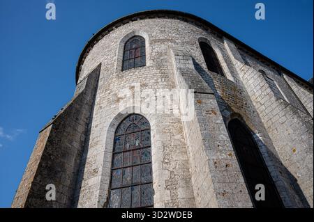 Vista ad angolo basso dell'abside della chiesa di San Lifredo a Meung-sur-Loire, con dettagli architettonici romanici e muratura in pietra Foto Stock