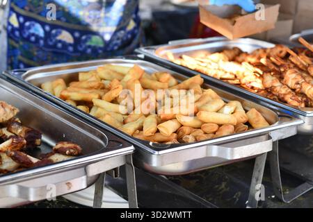 Involtini primavera thailandesi freschi fritti, cibo di strada in piatto a fette Foto Stock
