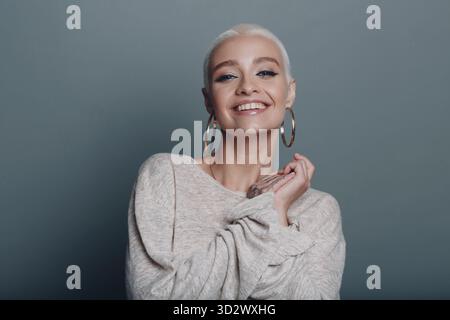 Giovane donna millenaria con capelli biondi corti e ritratto sorridente Foto Stock