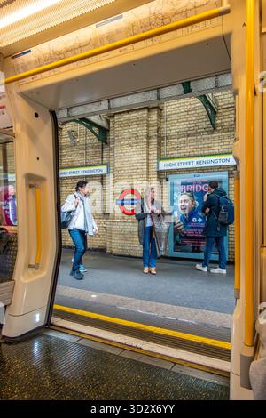 Guardando attraverso le porte aperte di un treno della metropolitana Circle Line London, mentre si fermava al binario di High Street Kensington Foto Stock