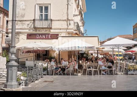 Pizzo, Italia â€“ 22 settembre 2025: Persone che gustano bevande e dessert al Dante cafÃ© e gelateria sotto ombrelloni nel centro storico di Pizzo, Calabria, Italia. Foto Stock