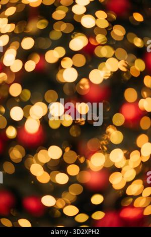 Luci bokeh rosse e dorate a fuoco tenue creano uno sfondo astratto caldo, festoso e magico, perfetto per i temi delle vacanze Foto Stock