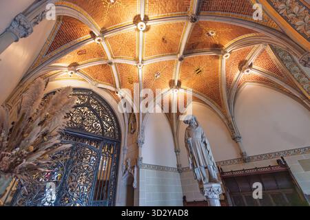 Soffitto della sala d'ingresso anteriore al castello De Haar (Kasteel de Haar), caratterizzato da volte gotiche, mattoni e un cancello decorativo in ferro battuto. Haarzuilens Foto Stock