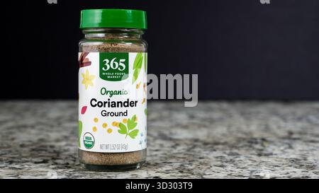NORWALK, CT, Stati Uniti d'America - 30 OTTOBRE 2025: Un barattolo di coriandolo macinato organico è posto in rilievo su un piano di granito. L'impostazione cattura un momento nel tempo Foto Stock