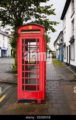 Llanidloes, Galles, Regno Unito - 1 settembre 2025; iconica cabina telefonica rossa britannica in condizioni meteorologiche su strada con corona Foto Stock