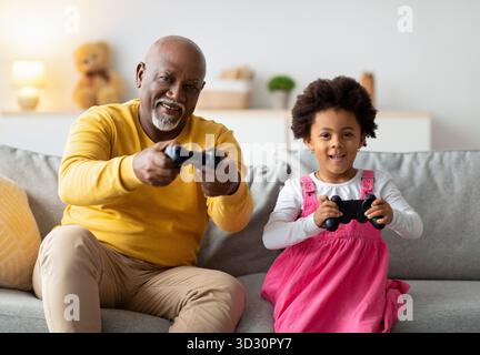 Momenti felici trascorsi a giocare ai videogiochi nel salotto con nonno e nipote Foto Stock