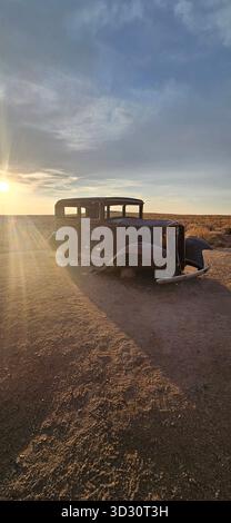 Rovine classiche della Studebaker del 1932 sulla Route 66 vicino al parco nazionale della foresta pietrificata durante il tramonto Foto Stock