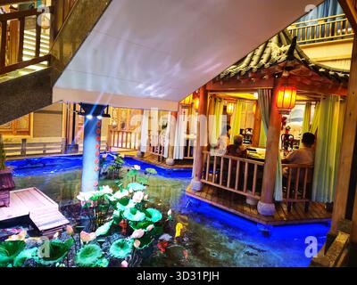 Cena per famiglie nel tradizionale ristorante cinese Pavilion con Lotus Pond Foto Stock