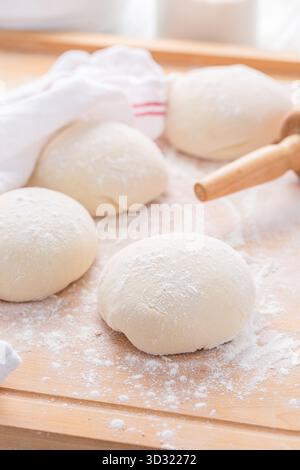 Pezzi di impasto di pane crudo su un tavolo da cucina in legno, pane da forno o pizza Foto Stock