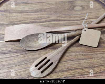 Set di utensili da cucina in legno su fondo in legno. I cucchiai di legno e le spatole sono comuni utensili da cucina che non graffiano i rivestimenti antiaderenti. C Foto Stock